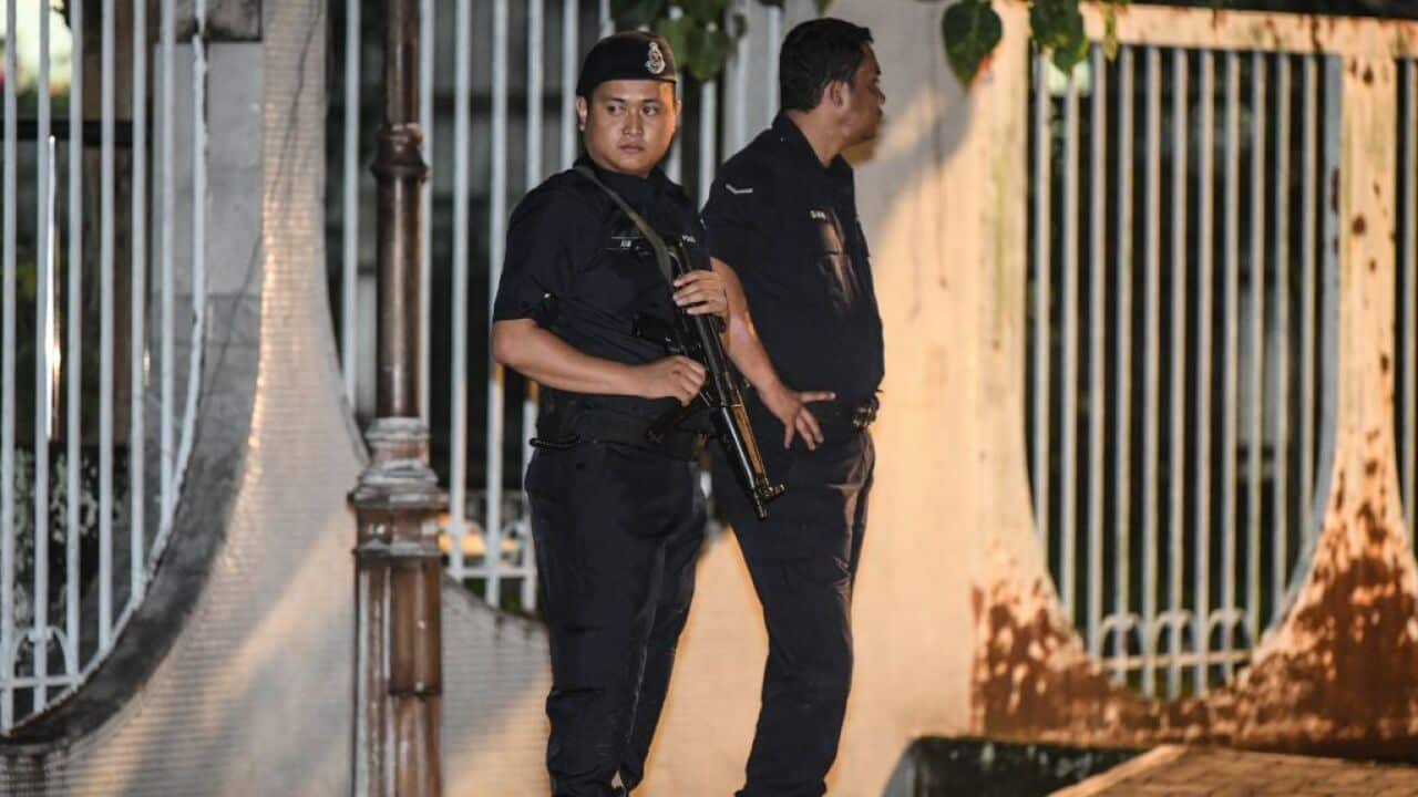 Malaysian police officers stand at the entrance of the former Prime Minister Najib Razak's residence in Kuala Lumpur.