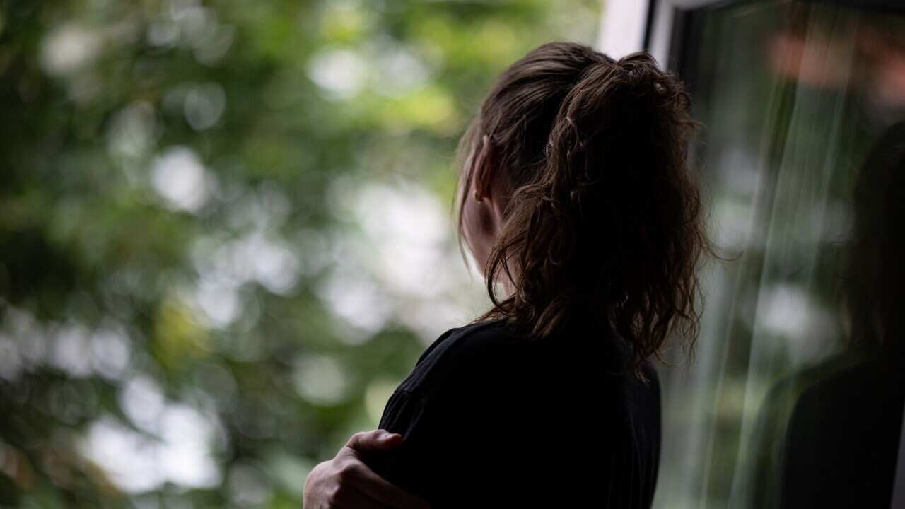 A woman looking out the window (Getty).
