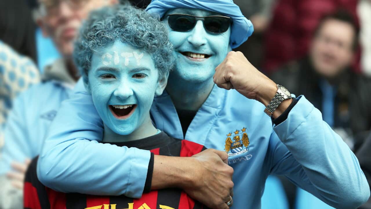 Die hard Manchester City fans smile in the stands during the 2012 English Premier League at the Etihad Stadium. (AAP)