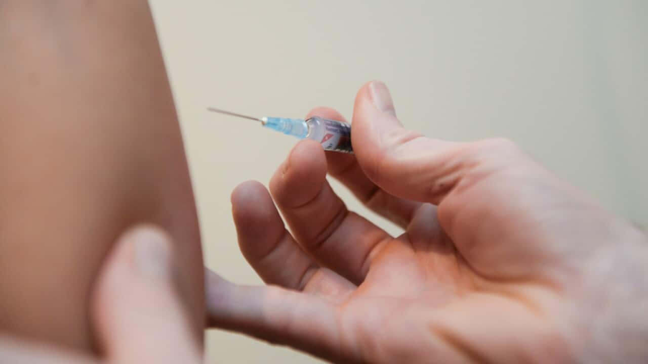 A doctor injects a vaccine at a clinic in Canberra, Friday, Aug. 2, 2013. (AAP Image/Lukas Coch) NO ARCHIVING