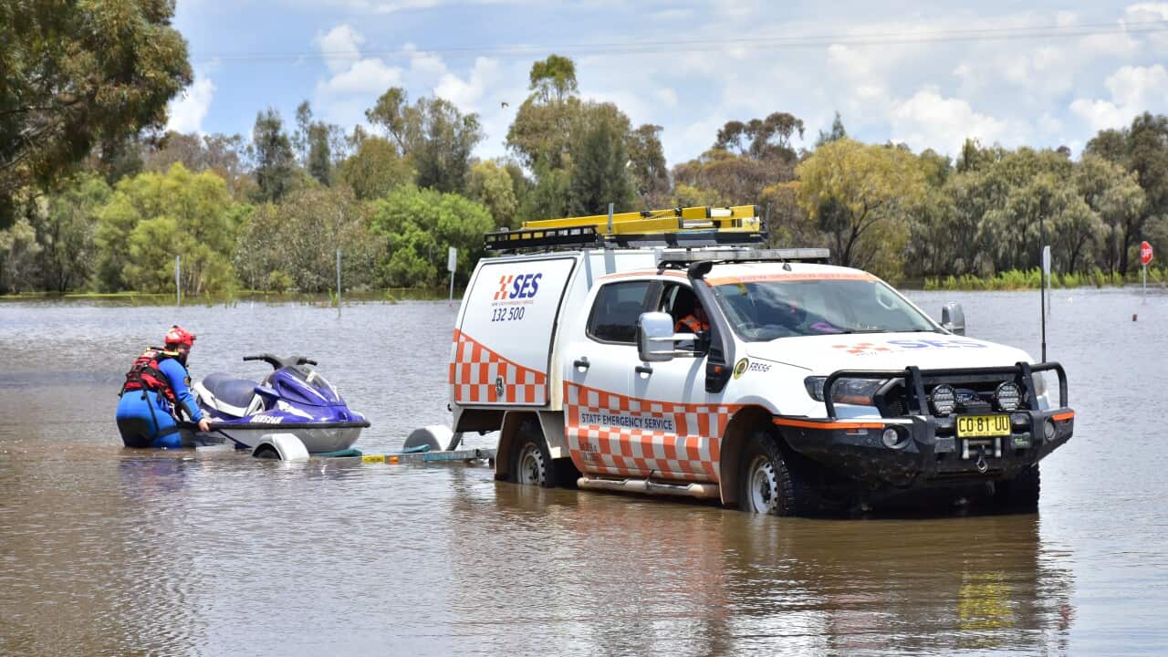 An SES vehicle unloads a jet ski into floodwaters