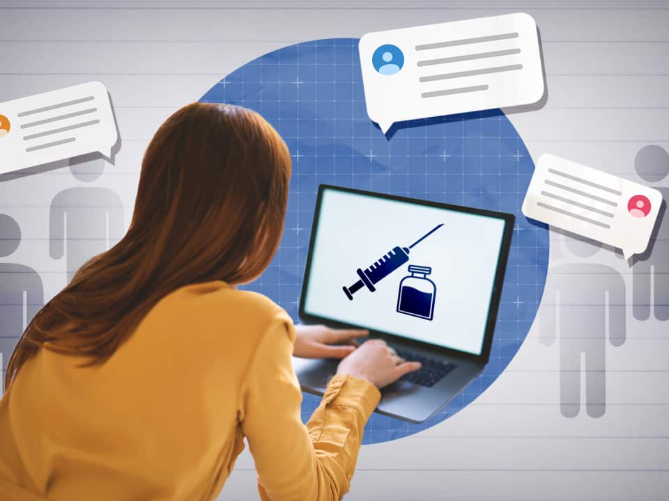 A woman at laptop with a vial and syringe on the screen.