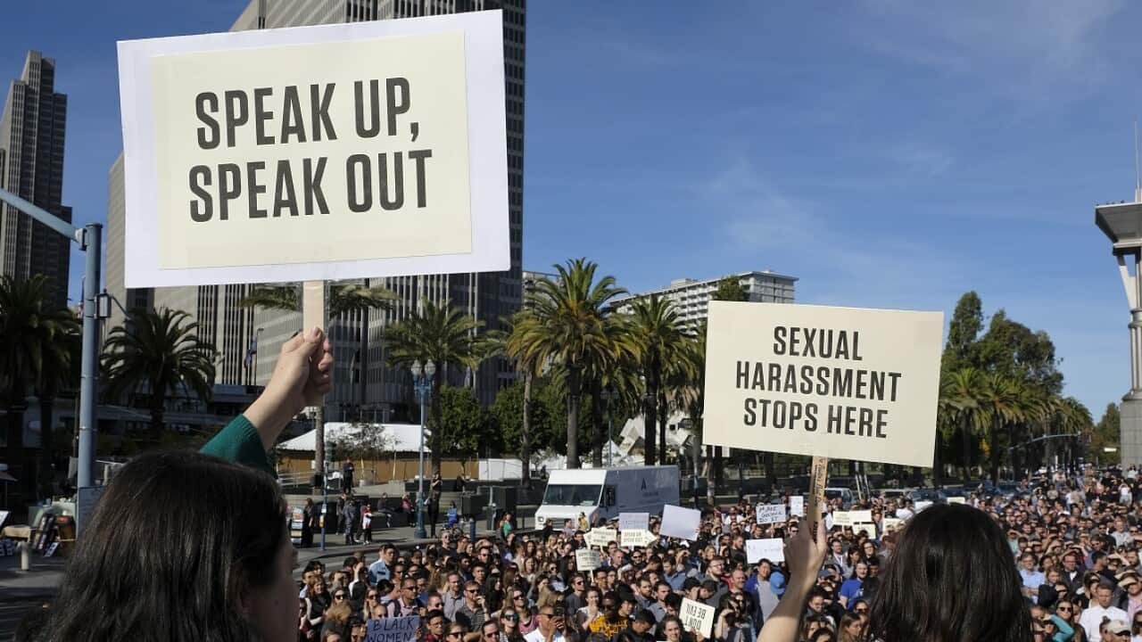 Google employees hold up signs during a walkout rally at Harry Bridges Plaza.
