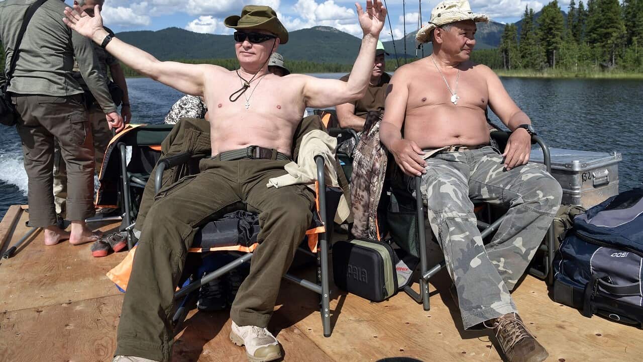 Russian President Vladimir Putin, left, and Defense Minister Sergei Shoigu rest after fishing during a mini-break in the Siberian Tyva region.