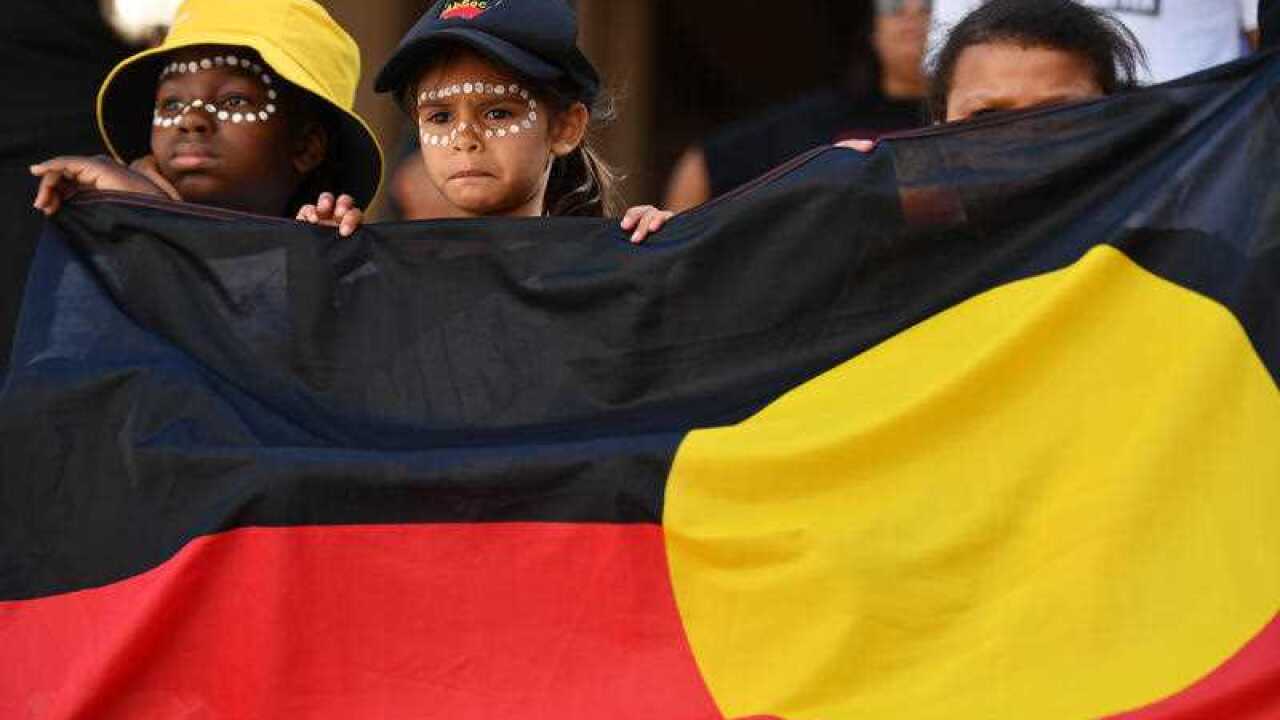 Children hold the Aboriginal Flag at a Black Deaths in Custody Rally at Town Hall in Sydney on 10 April 2021.