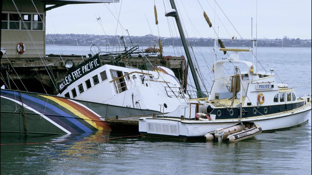 A police boat next to another boat at a dock that is sinking.