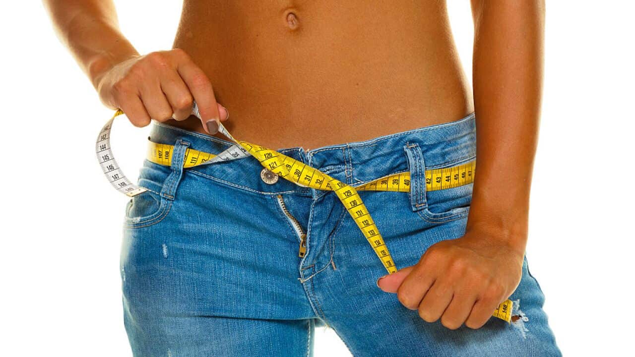 symbolic photo diet, woman wearing jeans with measuring tape
