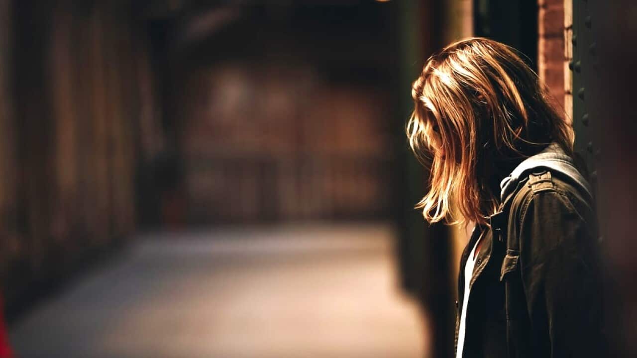 A girl stands in a hallway