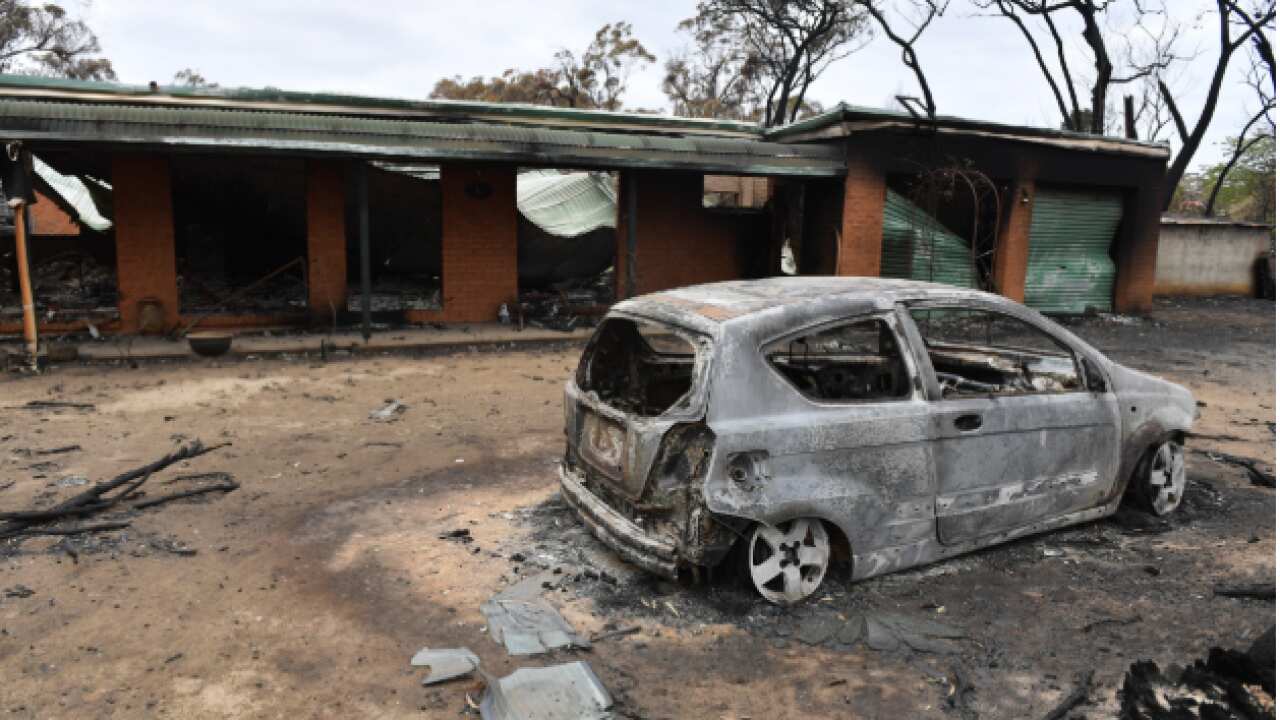 A house and car damaged by last Saturday's catastrophic bushfires in the Southern Highlands village of Balmoral. AAP