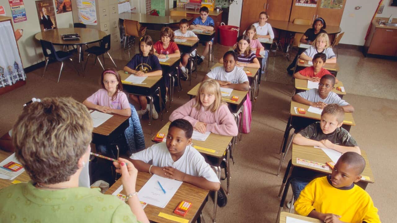 A teacher going over exam instructions with her class