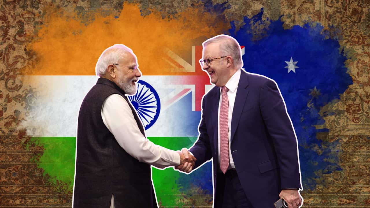 Indian PM Modi and Australian PM Albanese shake hands ahead of a backgrop of Indian and Australian flags merging, showing partnernship