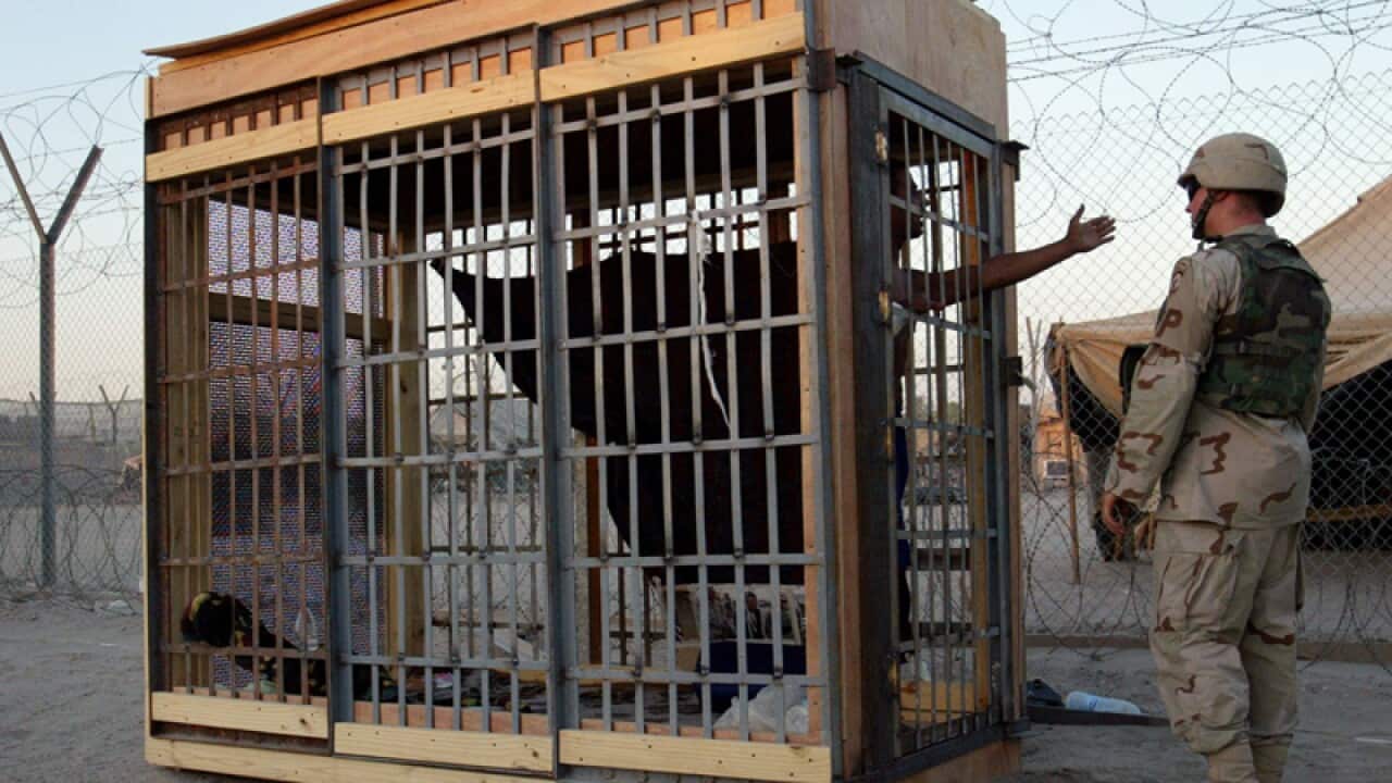 A detainee in an outdoor solitary cell at the Abu Ghraib prison