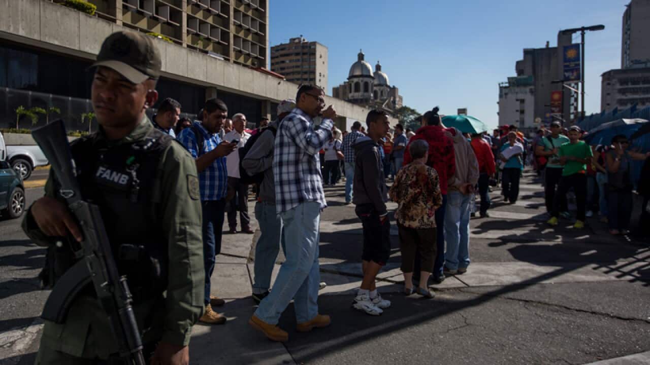 A group of people line up near the Central Bank of Venezuela