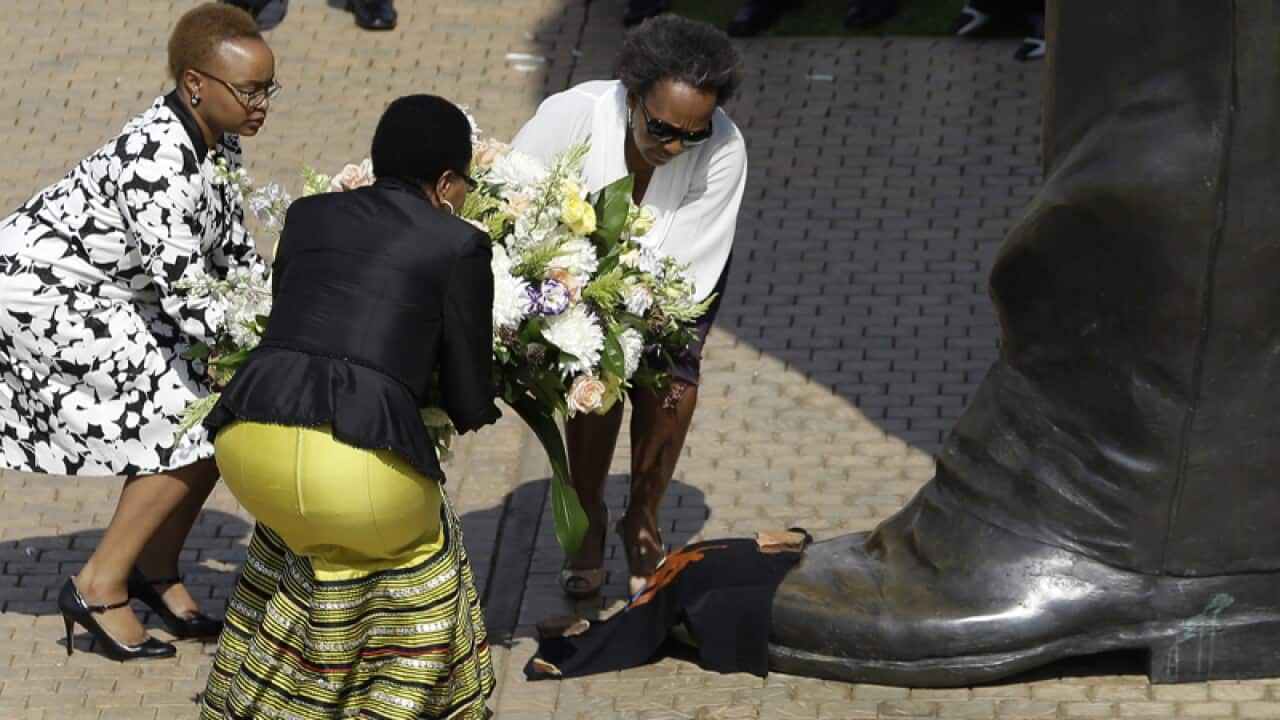 Nelson Mandela’s widow Graca Machel place a wreath to his statue