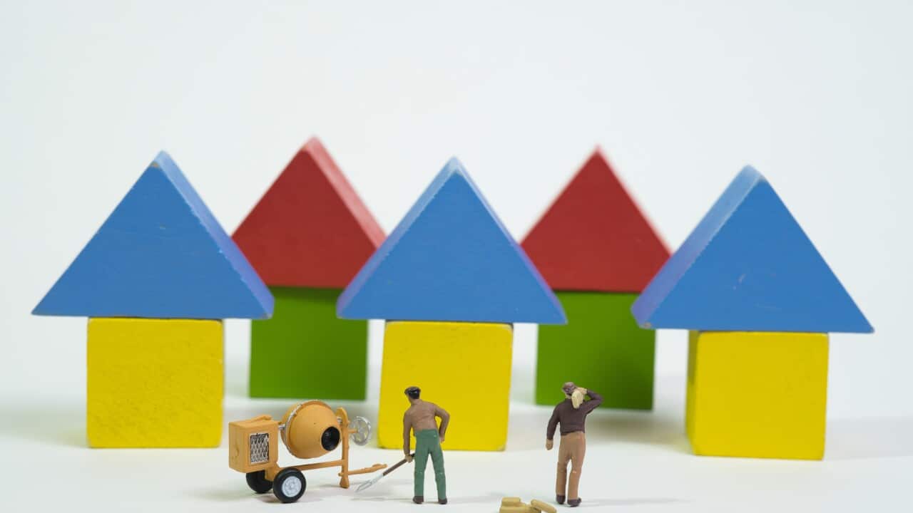 a team of workers with cement mixers is working on a colorful housing estate