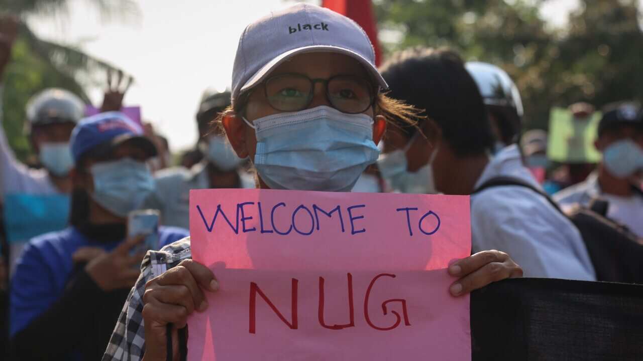 A demonstrator holds a banner that shows support for the National Unity Government (NUG), formed by leaders of the anti-coup protest and ethnic minority leaders