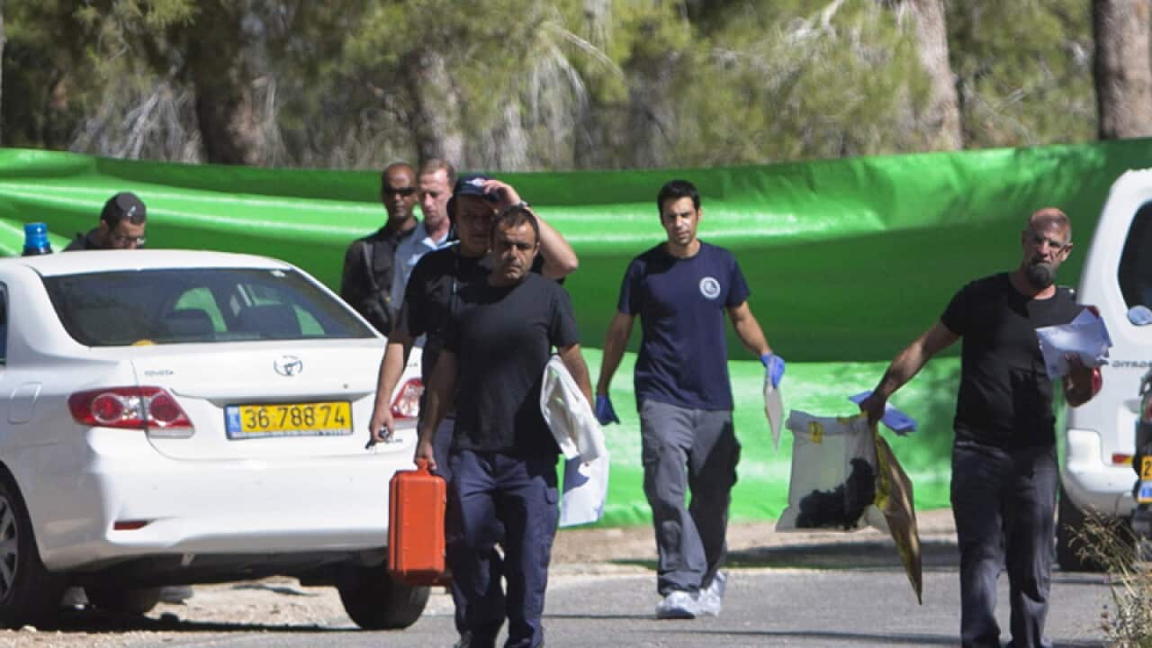 Israeli forensic police officers carry evidence bags