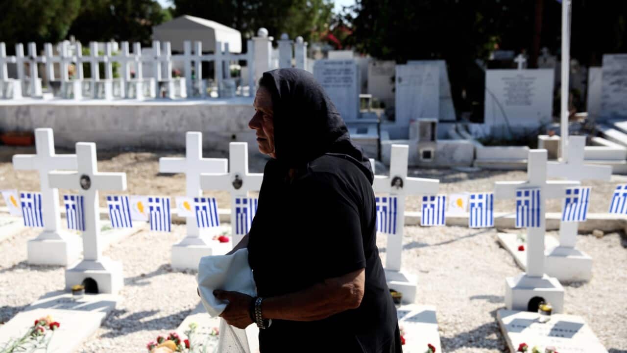 A Greek Cypriot woman attends a past ceremony for soldiers and police officers killed during the 1974 coup.