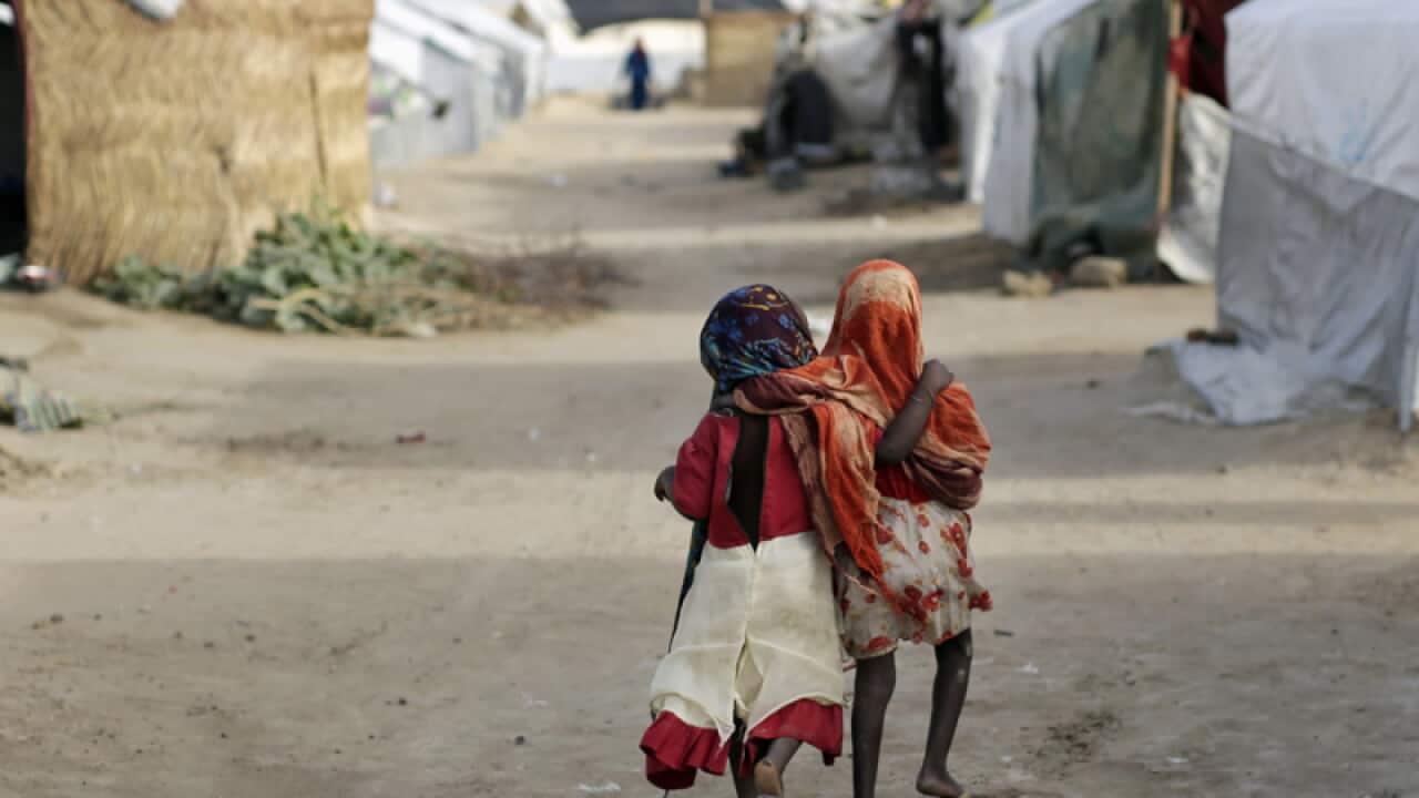 Ami and Ashbu, both three-years-old, walk arm in arm in Nigeria