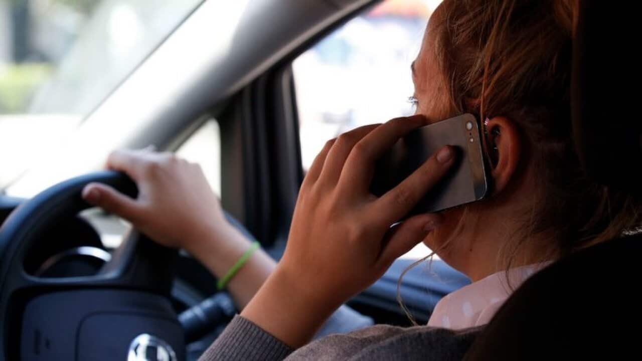 A woman using a mobile phone while driving.