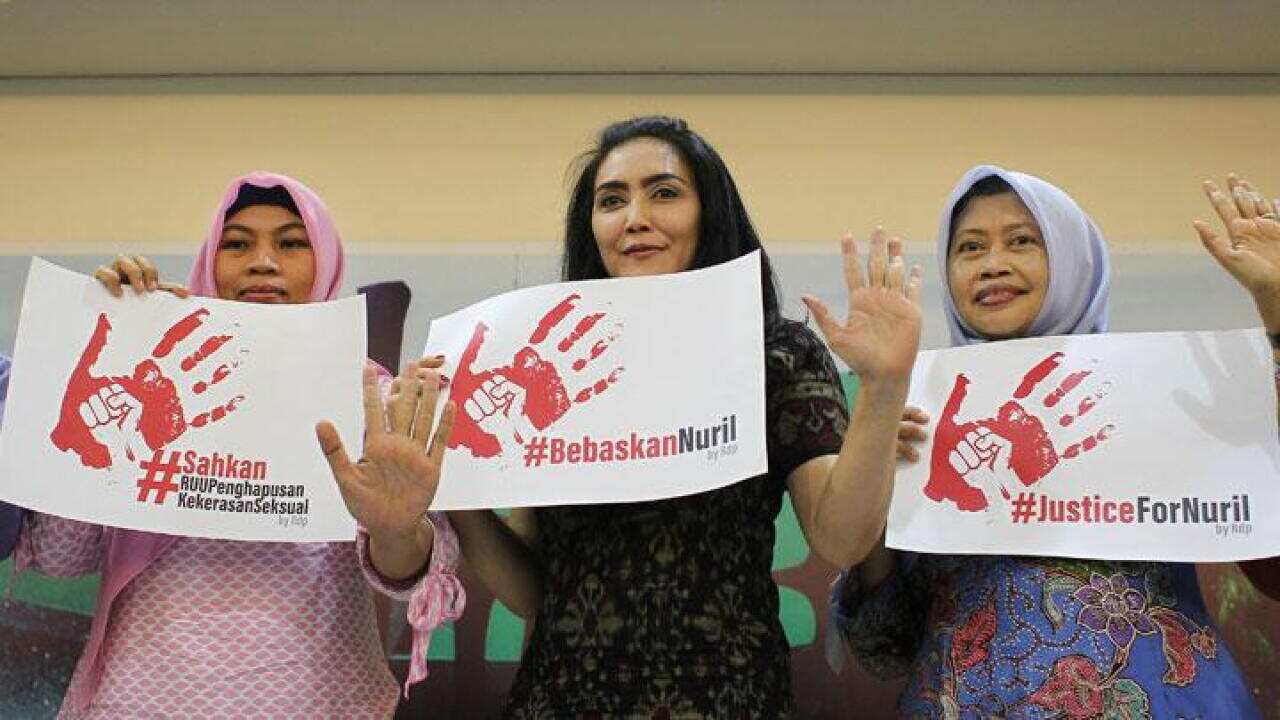 MP Rieke Diah Pitaloka (centre), Baiq Nuril Maknun (left) and Commissioner for Women's Rights Masruchah show posters demanding that Baiq Nuril be freed.