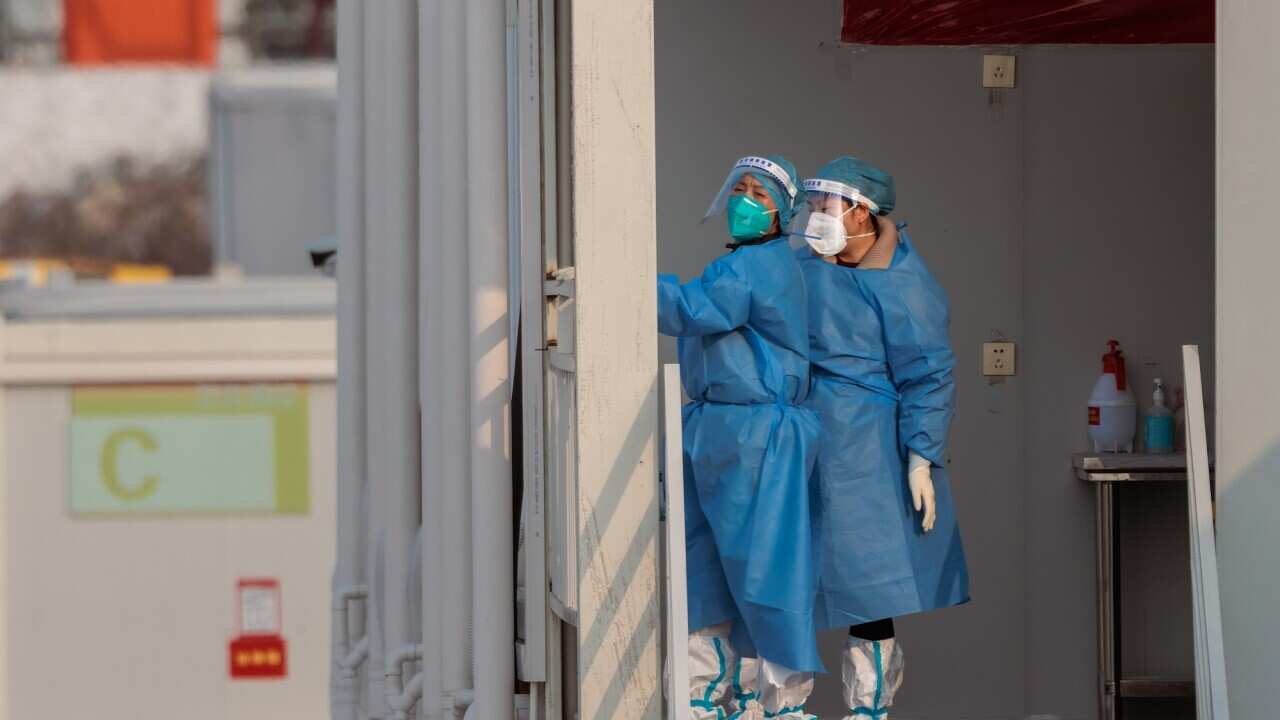People stand in a temporary settlement for people with mild or no symptoms provided by Shanghai city.
