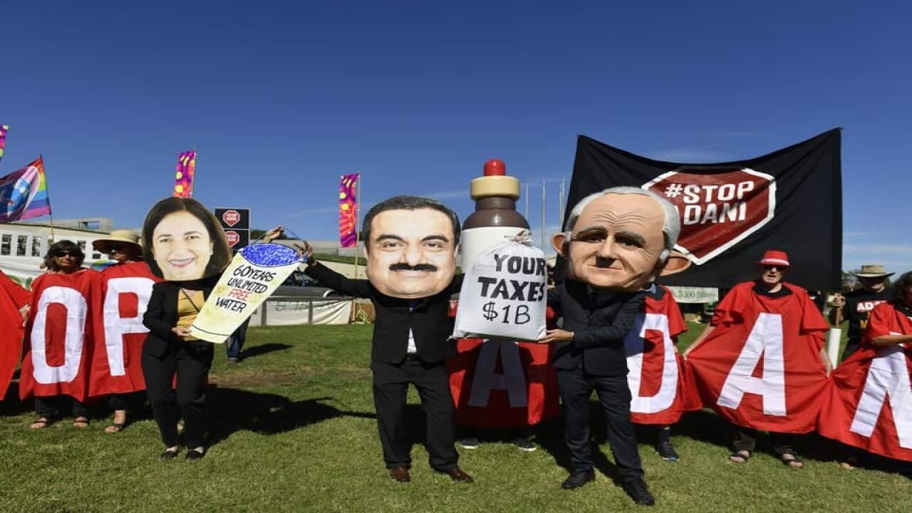 Protesters hold signs and banners at a Stop Adani Mine rally