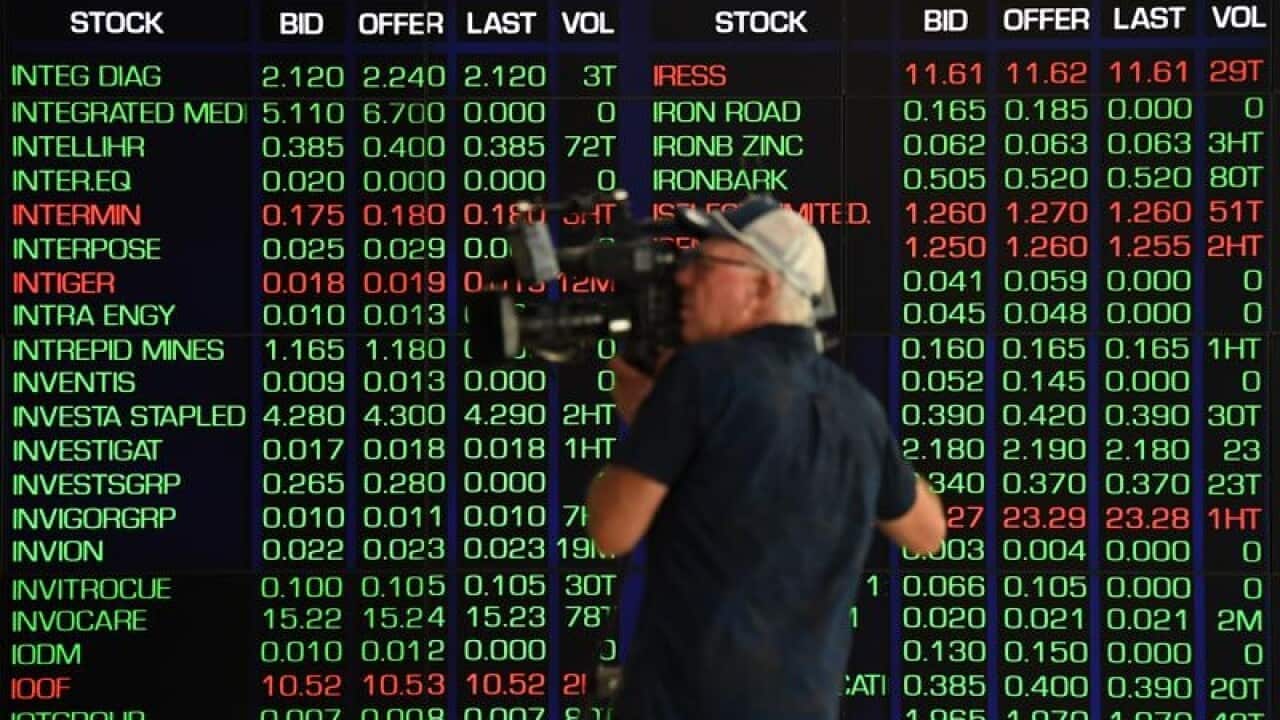 A cameraman films the market trading boards at the ASX