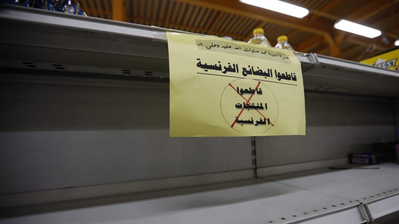 A placard reading in Arabic 'Boycott French products' is posted on shelves after French products were removed from supermarket shelves