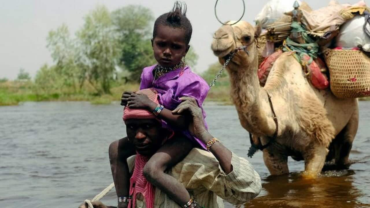 Herdsmen and others cross a tributary of Lake Chad to the village of N'Gouboua, Chad, Thursday, March 5, 2015