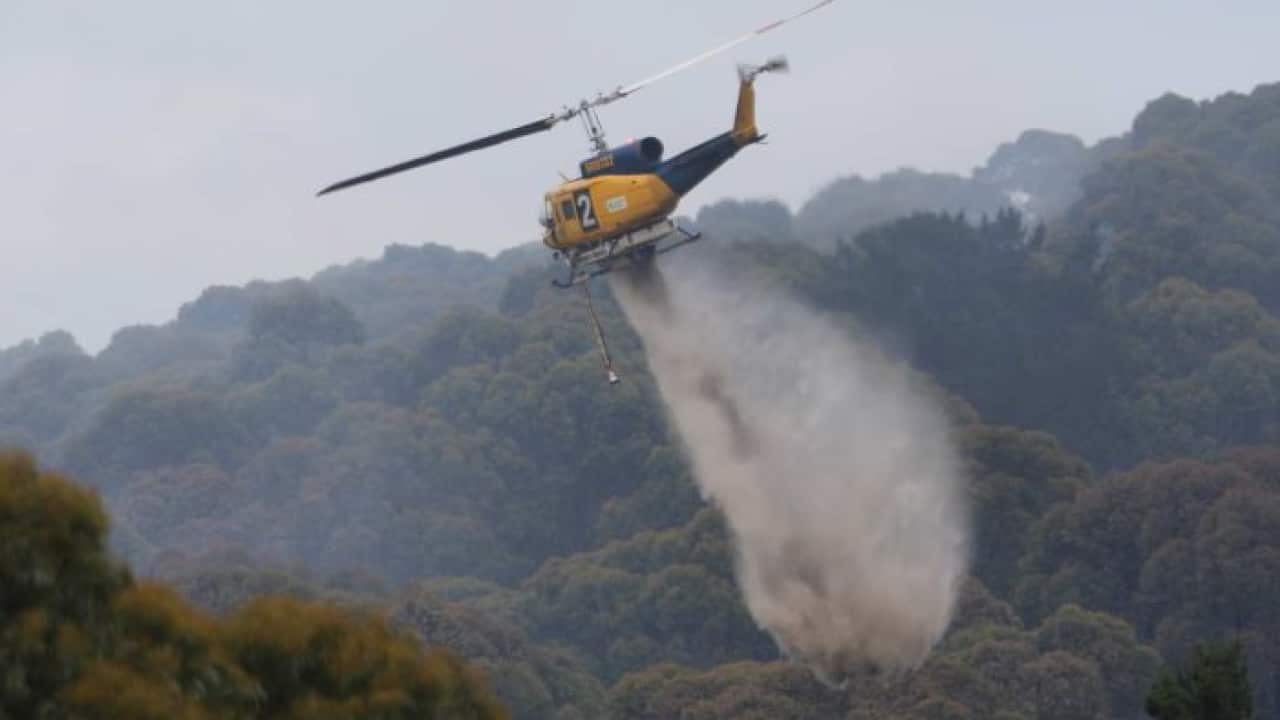 Helicopter waterbombs a fire at Bruny Island, Tasmania, Christmas Day, 2018