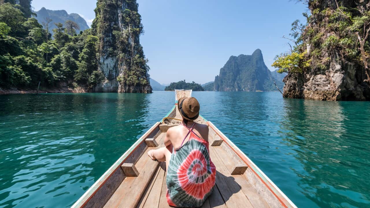 Woman in tie-dyed top enjoys boat ride along tranquil sea