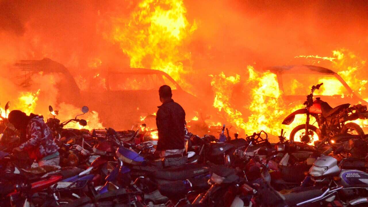 A man looks at vehicles on fire at a parking lot in Popayan Colombia, 28 May 2021. Colombia marks one month of continuous protests against the government and police brutality. EPA/Mario Parra