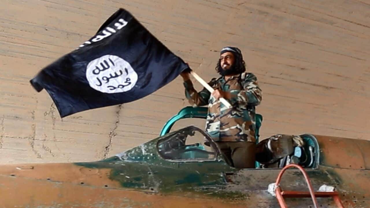An Islamic State fighter with a captured government fighter jet