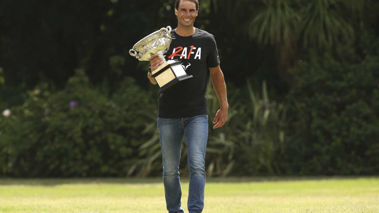 Men's singles champion Rafael Nadal of Spain poses for a photo with his trophy at Government House after the Australian Open in Melbourne, Australia, Monday, Jan. 31, 2022. (AP Photo/Hamish Blair)