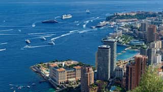 An aerial view of Monte Carlo, in the pricipality of Monaco. The image looks out to see where many boats and ships are moving around.