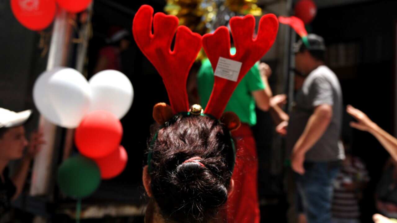 A woman queues for presents during the Wayside Chapel Street Party for the poor and homeless in Kings Cross in Sydney, Sunday, Dec. 25, 2011. (AAP Image/Mick Tsikas) NO ARCHIVING