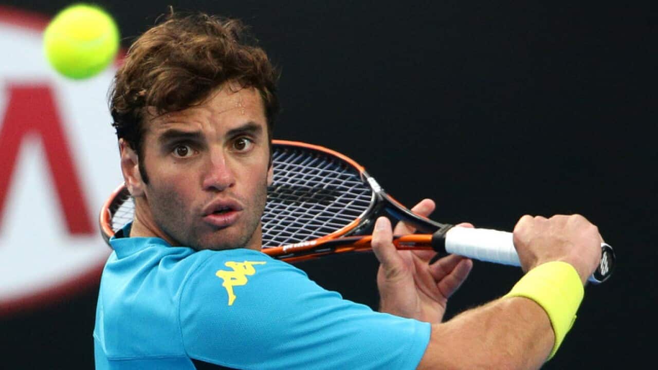 Malek Jaziri of Tunisia plays a shot to Nick Kyrgios