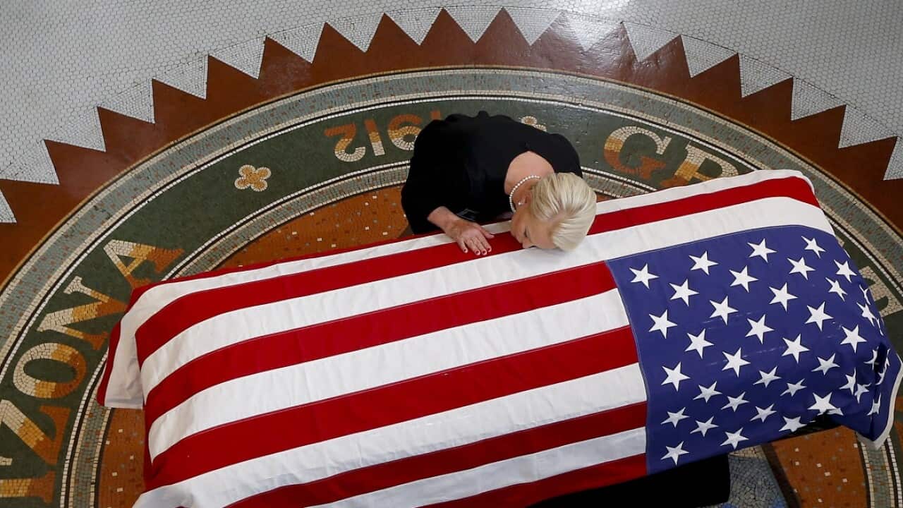 Cindy McCain touches the casket of John McCain.