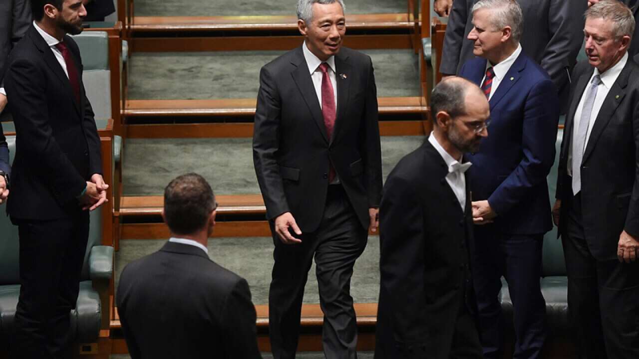 Lee Hsien Loong (C) arrives to address Parliament