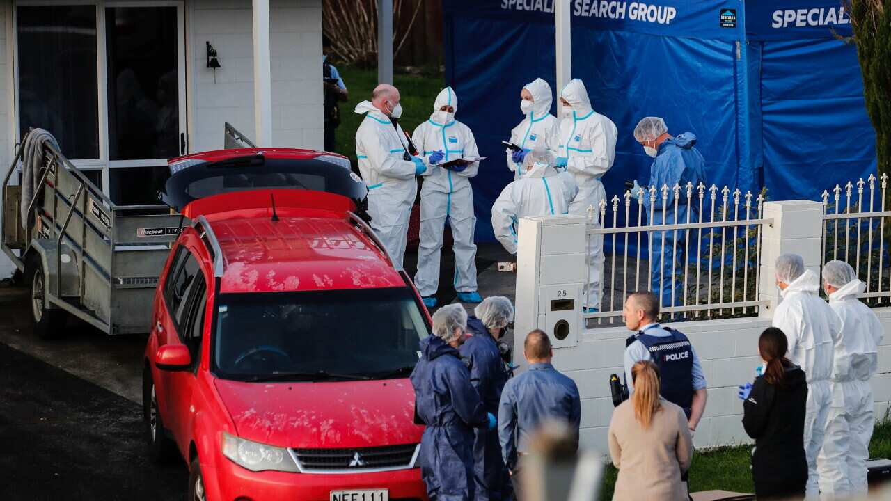 New Zealand police investigators work at a scene in Auckland on Aug. 11, 2022, after bodies were discovered in suitcases.