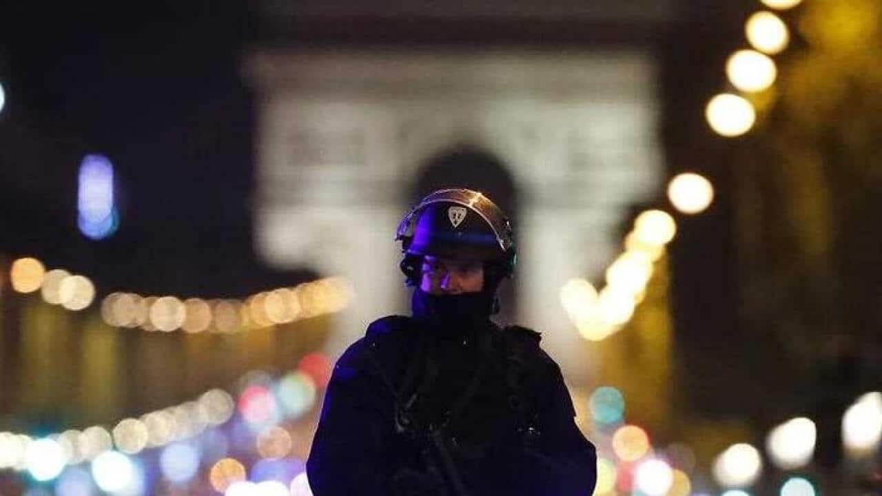 A French police officer guards the Champs Elysees after a man opened fire on police officers, killing one and wounding two others. (AAP)