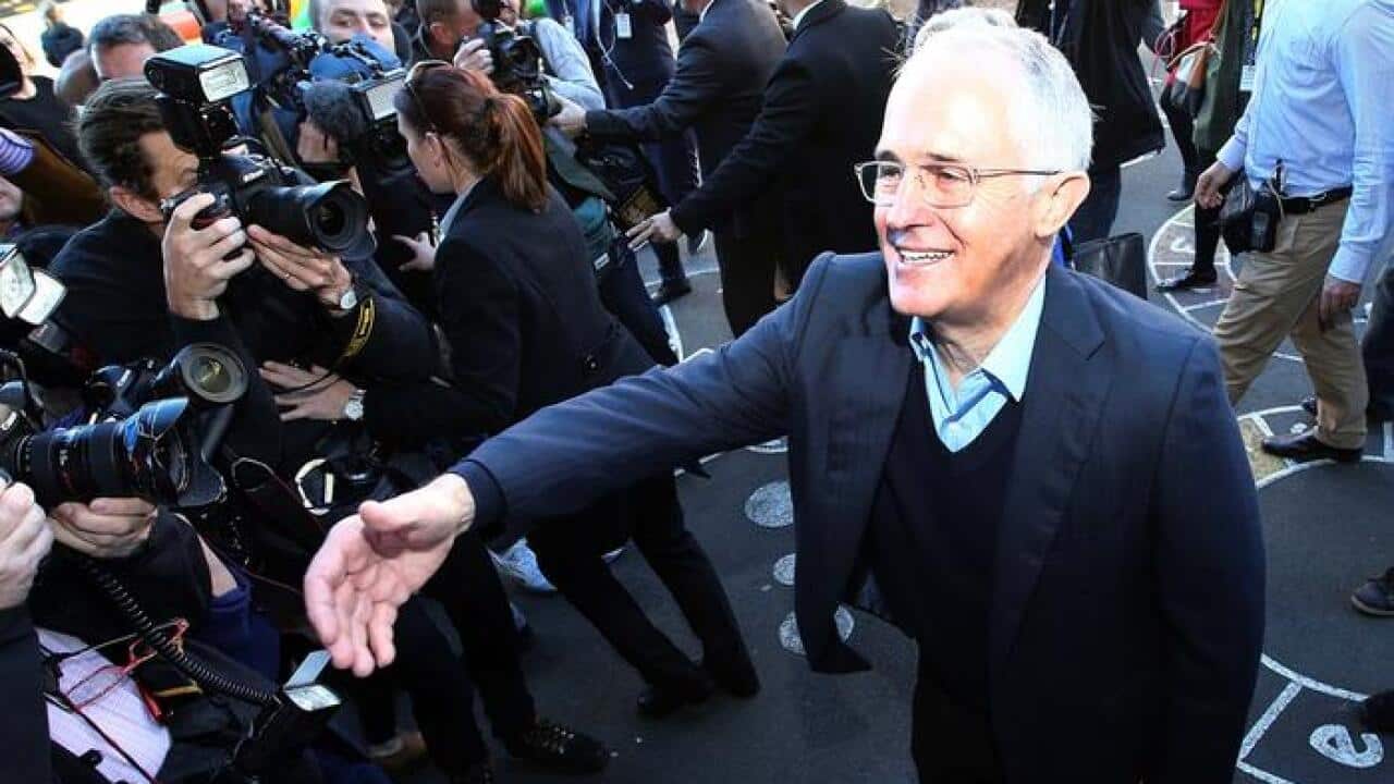 Prime Minister Malcolm Turnbulll greets supporters as he leaves his polling station after casting his votes in the federal election.