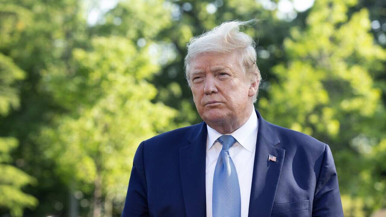 United States President Donald Trump speaks to members of the media on the South Lawn of the White House.