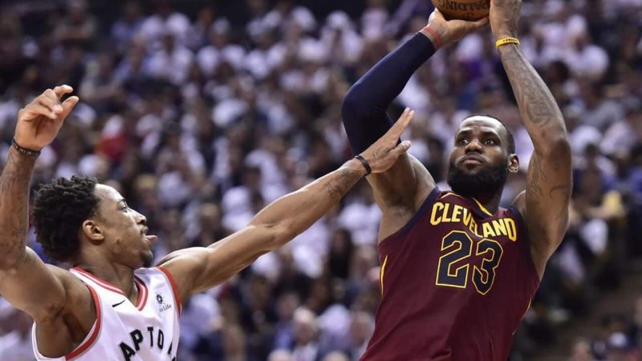 Cleveland's LeBron James shoots over Toronto's DeMar DeRozan
