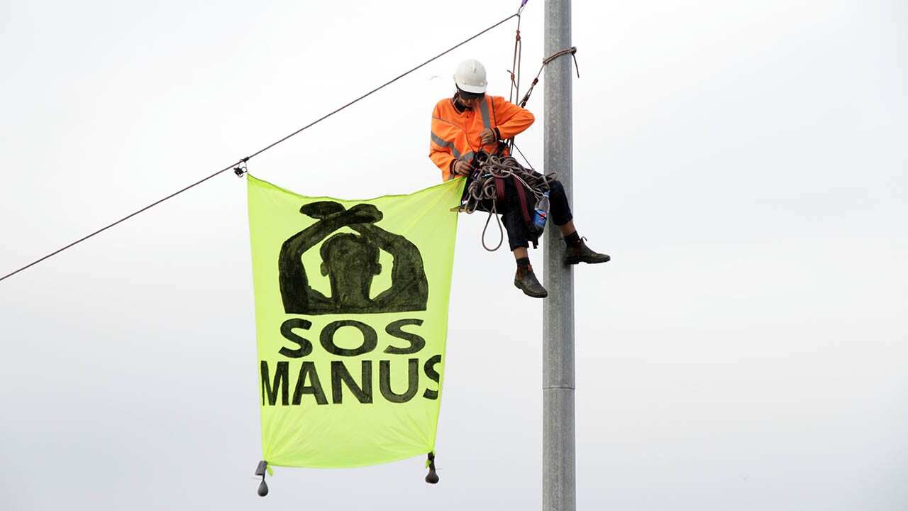 Activists block a Melbourne port container and unfurl banners.