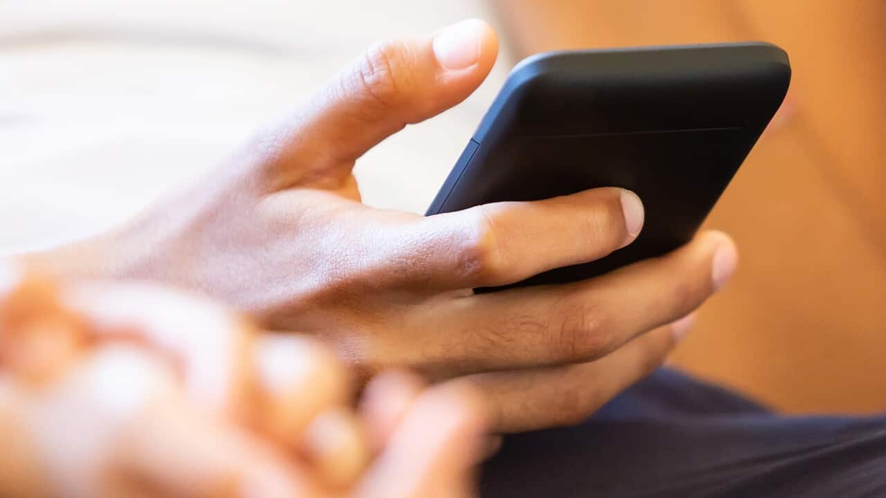 A young girl holding a smart phone