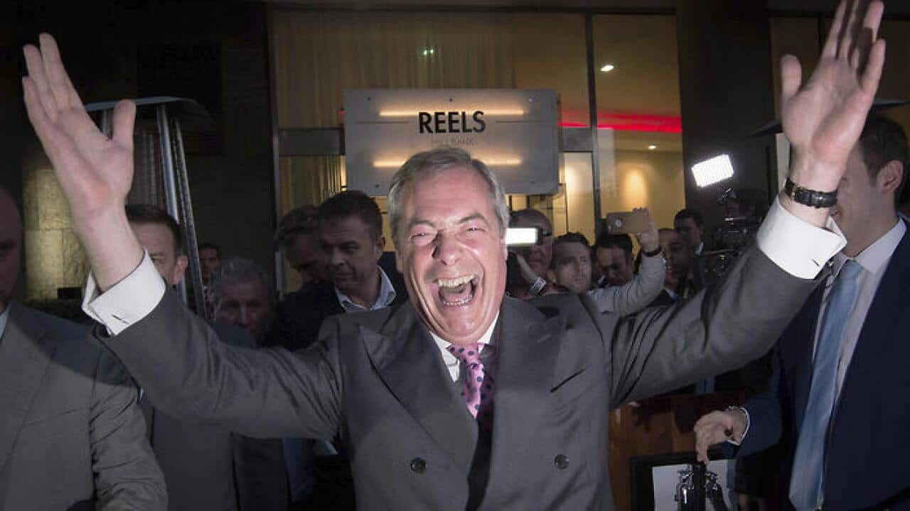 Nigel Farage, the leader of the UK Independence Party, celebrates and poses for photographers as he outside a "Leave EU" organisation party. (AAP)