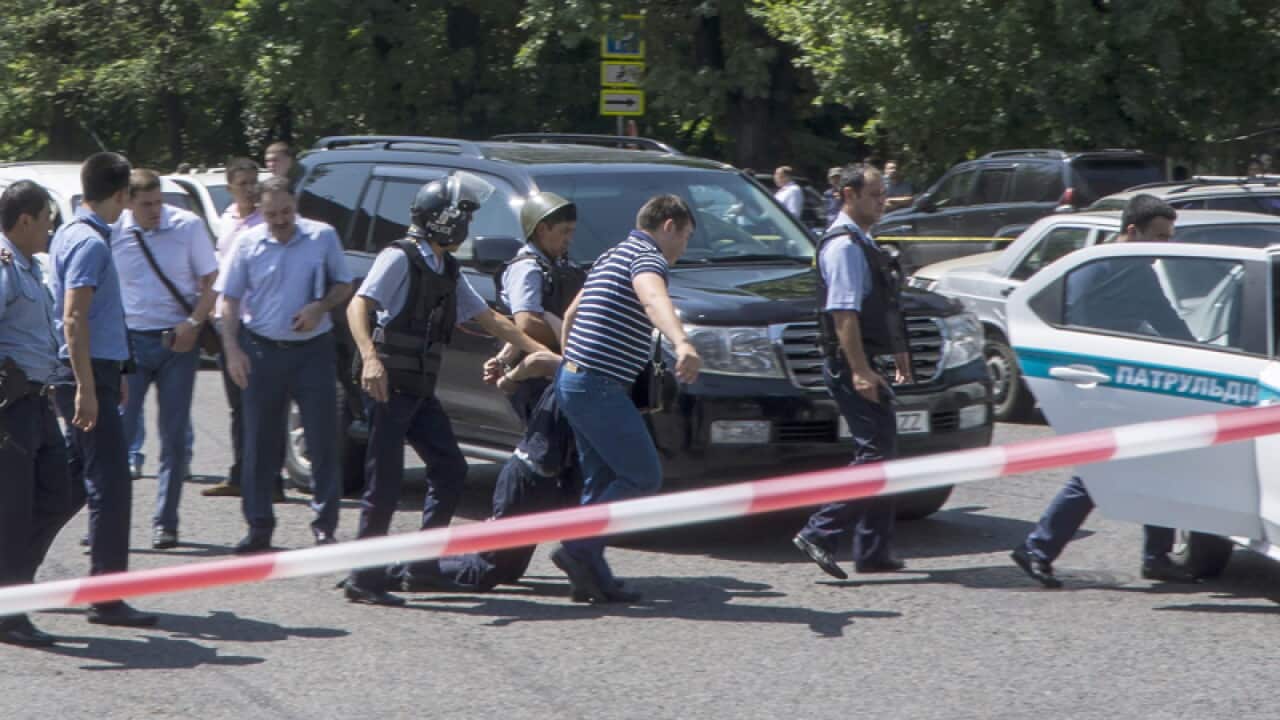 Kazakh policemen escort a detained suspect