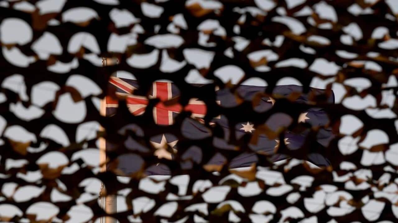 File image of the Australian flag flying seen through an army net.